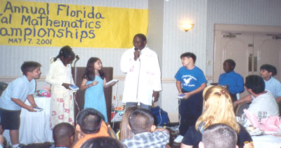 Children and host on stage at math championships